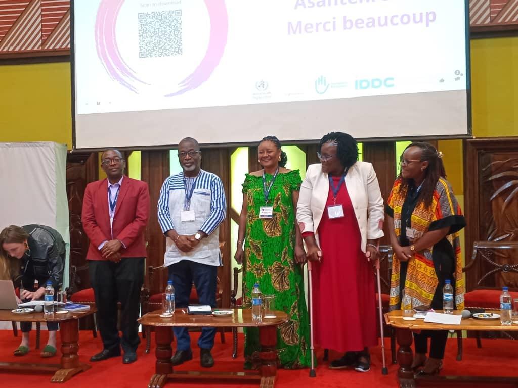 Panel of governance members standing on a stage during an event